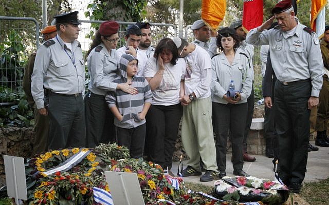 Friends and relatives of Hila Betzaleli cry as IDF Chief of General Staff Benny Gantz salutes after laying an Israeli flag on her grave, at the Mount Herzl military cemetery (photo credit: Miriam Alster/Flash90)