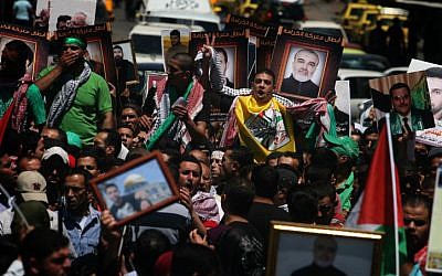 Protesters in Ramallah hold pictures of Palestinians jailed in Israel during a rally in solidarity with hunger strikers in 2012. (photo credit:  Issam Rimawi/Flash90)