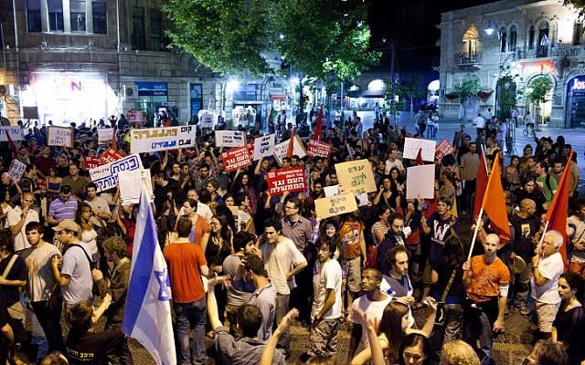 Demonstrators hold up signs as they take part in a protest march against rising living cost in Jerusalem, Saturday (photo credit: Yonatan Sindel/Flash90)