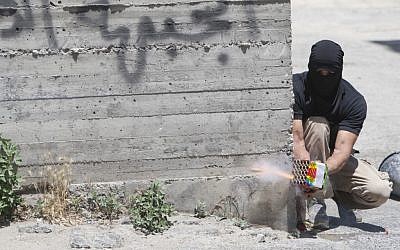 A Palestinian man shooting fireworks at troops in Issawiya in East Jerusalem on Tuesday (photo credit: Yonatan Sindel/Flash90) A Palestinian man shooting fireworks at troops in Issawiya in East Jerusalem on Tuesday (photo credit: Yonatan Sindel/Flash90)