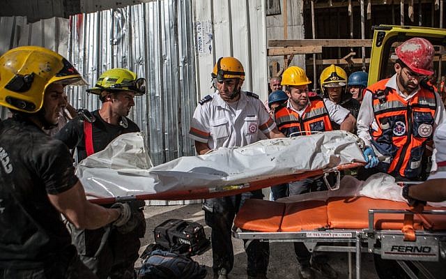 Emergency workers remove a body following a roof collapse on Wednesday (photo credit: Noam Moskowitz/Flash90) Emergency workers remove a body following a roof collapse on Wednesday (photo credit: Noam Moskowitz/Flash90)