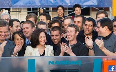 In this image provided by Facebook, Facebook founder, Chairman and CEO Mark Zuckerberg, center, applauds at the opening bell of the Nasdaq stock market, Friday. (photo credit: AP)