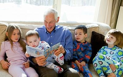 Harold Grinspoon, the founder of PJ Library, reads one of the program's books with a gaggle of children. (photo credit: PJ Library/JTA)