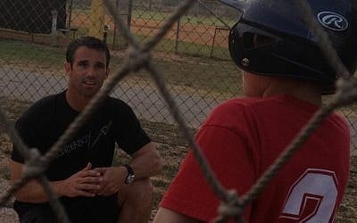 Former All-Star catcher Brad Ausmus gives some pointers to a young Israeli baseball enthusiast (photo credit: Michal Shmulovich)