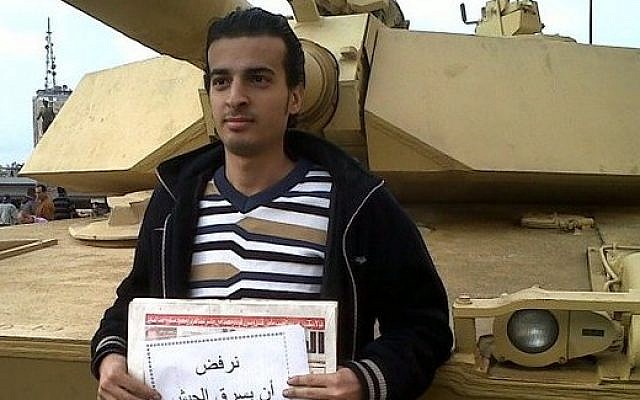 Egypt's first conscientious objector Maikel Nabil. His sign reads "we refuse the military stealing the people's revolution" (photo credit: courtesy)
