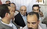 Egyptian presidential candidate Ahmed Shafiq, center, arrives to vote at a polling site in Cairo, Egypt, Wednesday. (photo credit: AP)