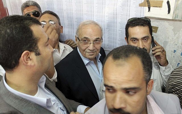 Egyptian presidential candidate Ahmed Shafiq, center, arrives to vote at a polling site in Cairo, Egypt, Wednesday. (photo credit: AP) Egyptian presidential candidate Ahmed Shafiq, center, arrives to vote at a polling site in Cairo, Egypt, Wednesday. (photo credit: AP)