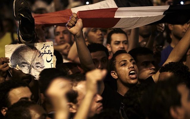 Young Egyptians return to Tahrir Square on Monday night to protest the results of the presidential election. (photo credit: Fredrik Persson/AP) Young Egyptians return to Tahrir Square on Monday night to protest the results of the presidential election. (photo credit: Fredrik Persson/AP)