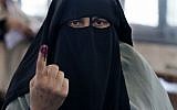 An Egyptian woman shows her inked finger after casting her vote in Alexandria (photo credit: AP Photo/Khalil Hamra)
