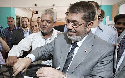 Muslim Brotherhood presidential candidate Mohammed Morsi casts his vote at a polling station in Zakazik, 80 Kilometers (50 miles) north of Cairo on Wednesday. (photo credit: Ahmed Gomaa/AP)
