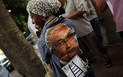 An Egyptian woman wears a shirt with presidential candidate Ahmed Shafiq's face on the back Saturday. (photo credit: AP Photo/Khalil Hamra)