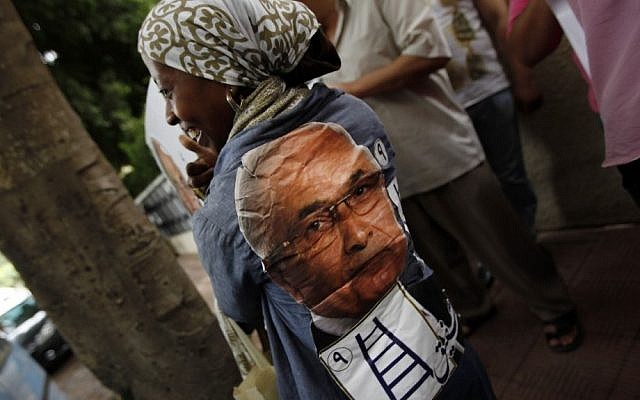 An Egyptian woman wears a shirt with presidential candidate Ahmed Shafiq's face on the back Saturday. (photo credit: AP Photo/Khalil Hamra)