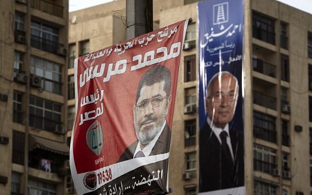 Campaign posters supporting presidential candidates Mohammed Morsi, left, and Ahmed Shafiq, right, hang in Cairo on Monday (photo credit: Fredrik Persson/AP) Campaign posters supporting presidential candidates Mohammed Morsi, left, and Ahmed Shafiq, right, hang in Cairo on Monday (photo credit: Fredrik Persson/AP)