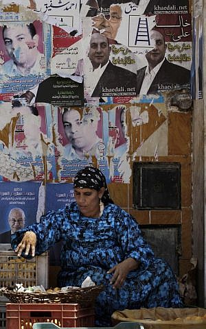 An Egyptian street vendor sells fruits in front of a wall filled with defaced posters of presidential candidates in Cairo, Egypt, Monday, May, 21, 2012 (photo credit: AP/Hasan Jamali) An Egyptian street vendor sells fruits in front of a wall filled with defaced posters of presidential candidates in Cairo, Egypt, Monday, May, 21, 2012 (photo credit: AP/Hasan Jamali)
