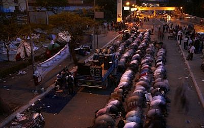 Followers of Egyptian Muslim cleric and former candidate for Egyptian presidency, Hazem Salah Abu Ismail, pray at the location of their sit in on the road leading to the Defense Ministry, in Cairo, Egypt. (photo credit: AP/Fredrik Persson)