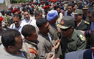 Field Marshal Hussein Tantawi, right, greets mourners at a military funeral for a commando killed in clashes with protesters in Cairo on Saturday (photo credit: AP Photo)