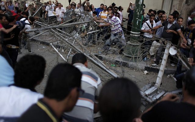 Egyptian protesters remove barbed wire blocking the road during a rally demanding the release of fellow activists (photo credit: AP/Nasser Nasser)
