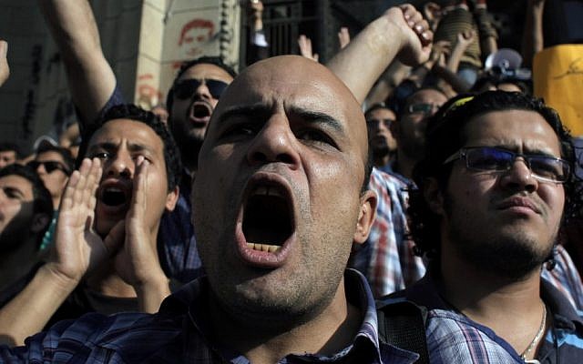 Egyptian protesters chant anti-military slogans during a rally demanding the release of fellow activists who were detained during a protest last Friday in front of the Ministry of Defense (photo credit: Nasser Nasser/AP)