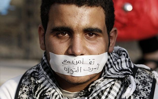An Egyptian man wearing a banner on his mouth that reads, "with the revolutionary families," attends a demonstration in Cairo, on Wednesday (photo credit: AP/Fredrik Persson) An Egyptian man wearing a banner on his mouth that reads, "with the revolutionary families," attends a demonstration in Cairo, on Wednesday (photo credit: AP/Fredrik Persson)