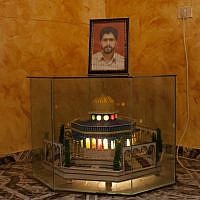 A picture of Palestinian Jaffar E'zedin sits on top of a model of the Dome of the Rock which he had made while doing a previous prison sentence, at his family home in the West Bank village of Arrabeh. Jaffar is imrisoned in Israel without charges and is on a hunger strike since the second day after his arrest on March 25. (photo credit: AP/Bernat Armangue)