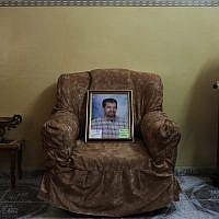 A picture of Palestinian Omar Abu Shallal, jailed in Israel and on a hunger strike since Aug. 15, sits on the sofa in the living room of his family house, in the West Bank city of Nablus. (photo credit: AP/Bernat Armangue)