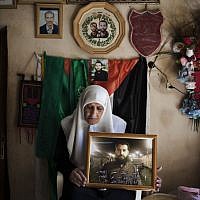 Harbiya al-Batall holds a picture of her 33 year old son Hasan Safadi at their family home in the West Bank city of Nablus. Hasan Safadi was arrested on June 29 and is held without charges since. Hasan is on a hunger strike since March 3. (photo credit: AP/Bernat Armangue)