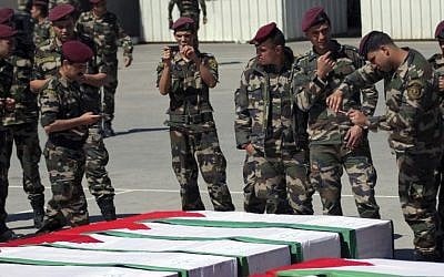 Members of the Palestinian security forces take pictures as they stand around coffins containing the remains of bodies of Palestinian terrorists transferred from Israel to the Palestinian Authority in 2012 (photo credit: AP/Mohammed Ballas)