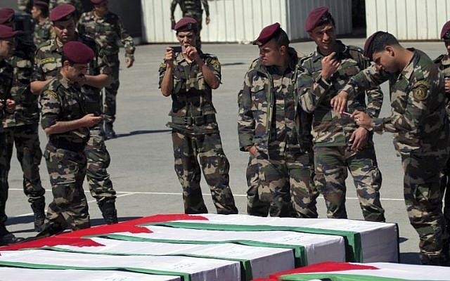 Members of the Palestinian security forces take pictures as they stand around coffins containing the remains of bodies of Palestinian terrorists transferred from Israel to the Palestinian Authority in 2012 (photo credit: AP/Mohammed Ballas) Members of the Palestinian security forces take pictures as they stand around coffins containing the remains of bodies of Palestinian terrorists transferred from Israel to the Palestinian Authority in 2012 (photo credit: AP/Mohammed Ballas)