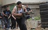 A Sunni gunman runs with his weapon during clashes in the northern port city of Tripoli, Lebanon, this month (photo credit: Hussein Malla/AP)