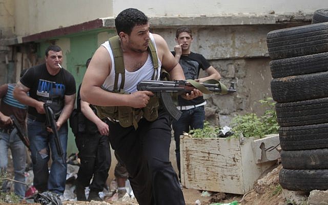 A Sunni gunman runs with his weapon during clashes in the northern port city of Tripoli, Lebanon, this month (photo credit: Hussein Malla/AP) A Sunni gunman runs with his weapon during clashes in the northern port city of Tripoli, Lebanon, this month (photo credit: Hussein Malla/AP)
