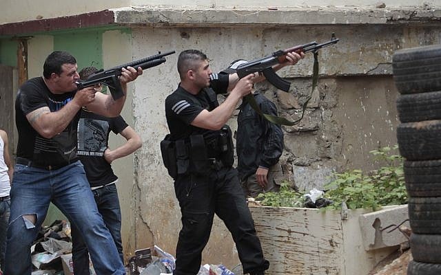 Sunni gunmen fire their rifles during clashes, in the northern port city of Tripoli, Lebanon, Sunday. (photo credit: AP/Hussein Malla) Sunni gunmen fire their rifles during clashes, in the northern port city of Tripoli, Lebanon, Sunday. (photo credit: AP/Hussein Malla)