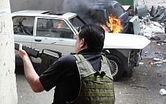 A Sunni gunman fires during running gun battles in the northern port city of Tripoli, Lebanon. (photo credit: AP/Hussein Malla)
