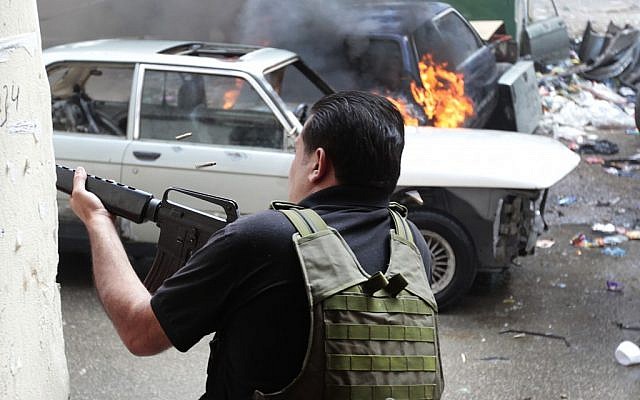A Sunni gunman fires during running gun battles in the northern port city of Tripoli, Lebanon. (photo credit: AP/Hussein Malla)