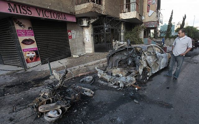 Burnt vehicles in Beirut following clashes between supporters and opponents of the Assad regime (photo credit: AP/Hussein Malla) Burnt vehicles in Beirut following clashes between supporters and opponents of the Assad regime (photo credit: AP/Hussein Malla)