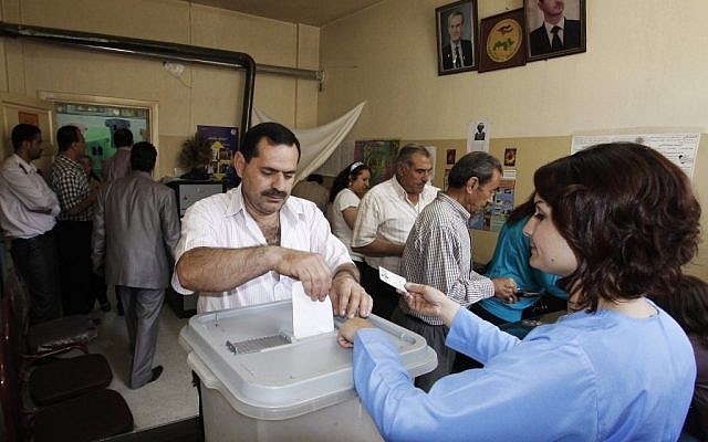 A man casts his vote at a polling station during the parliamentary elections in Damascus on Monday. (photo credit: Muzaffar Salman/AP)