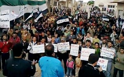 Syrians chanting anti-regime slogans during a demonstration in Idlib, north Syria, Sunday (photo credit: AP Photo/Shaam News Network via AP video)