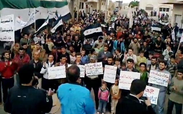 Syrians chanting anti-regime slogans during a demonstration in Idlib, north Syria, Sunday (photo credit: AP Photo/Shaam News Network via AP video) Syrians chanting anti-regime slogans during a demonstration in Idlib, north Syria, Sunday (photo credit: AP Photo/Shaam News Network via AP video)