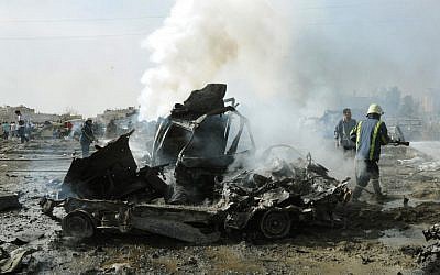 Syrian firefighters extinguish a burning car following explosions in Damascus (photo credit: AP Photo/SANA)