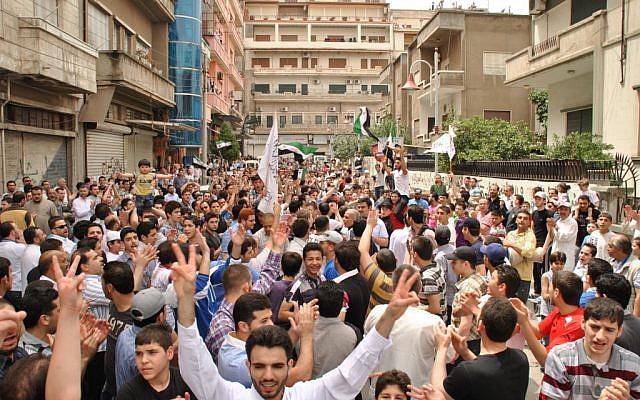 Syrians chant slogans during an opposition demonstration in Homs, Syria. The opposition is becoming increasingly divided over policies. (photo credit: AP) Syrians chant slogans during an opposition demonstration in Homs, Syria. The opposition is becoming increasingly divided over policies. (photo credit: AP)