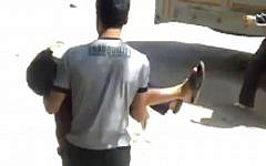 This image shows a wounded child being evacuated in Aleppo, Syria in May-- on a day in which some 50 civilians, including 13 children, were killed. (photo credit: AP/Shaam News Network via AP video)