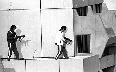 Two West German policemen, armed with submachine guns and wearing tracksuits, get into position on the roof of the building where armed Palestinian terrorists were holding Israel Olympic team members hostage, September 5, 1972 (photo credit:AP)