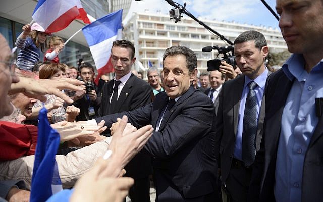 France's president and conservative candidate for re-election in 2012, Nicolas Sarkozy, shakes hands with crowds of supporters (photo credit: AP/Eric Feferberg)
