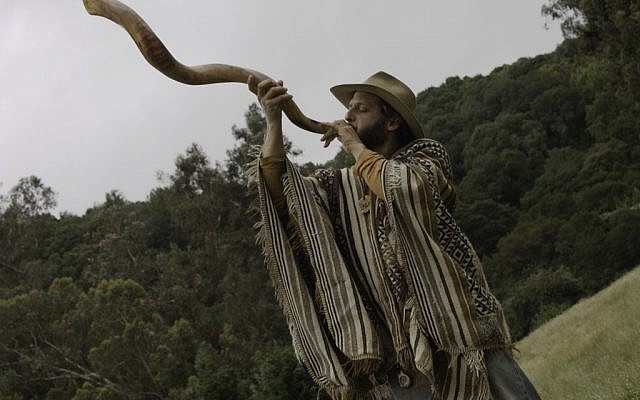 Zelig Golden blowing the shofar during a Wilderness Torah Shavuot event at a park near Oakland, California. (photo credit:Kayla Garelick/JTA)