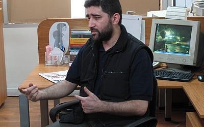 Turkish journalist Adem Ozkose gives an interview at the office of his newspaper, Milat, in Istanbul on Monday. Ozkose and a colleague, Hamit Coskun, were freed this weekend after Iran, a staunch backer of Syrian President Bashar Assad, intervened to help secure their release. (photo credit: Chris Torchia/AP))
