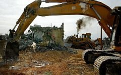 Bulldozers demolish a house during the evacuation of the West Bank outpost of Amona in 2006. Resident of the current outpost hope a hunger strike will prevent a repeat of the events. (photo credit: Olivier Fitoussi/Flash90)