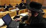 An ultra-Orthodox man studying religious texts with a computer at a Yeshiva in Jerusalem (photo credit: Nati Shohat/Flash90)