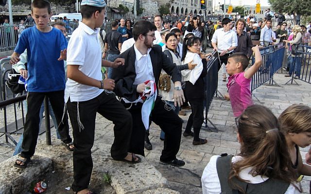 A young Arab boy fights with a Jewish man during a march celebrating Jerusalem Day (photo credit: Nati Shohat/Flash90)
