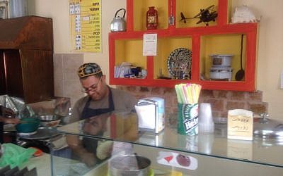 Yuval Tzadok, in a perpetually good mood, serving up the goods (Photo credit: Mitch Ginsburg/ Times of Israel)
