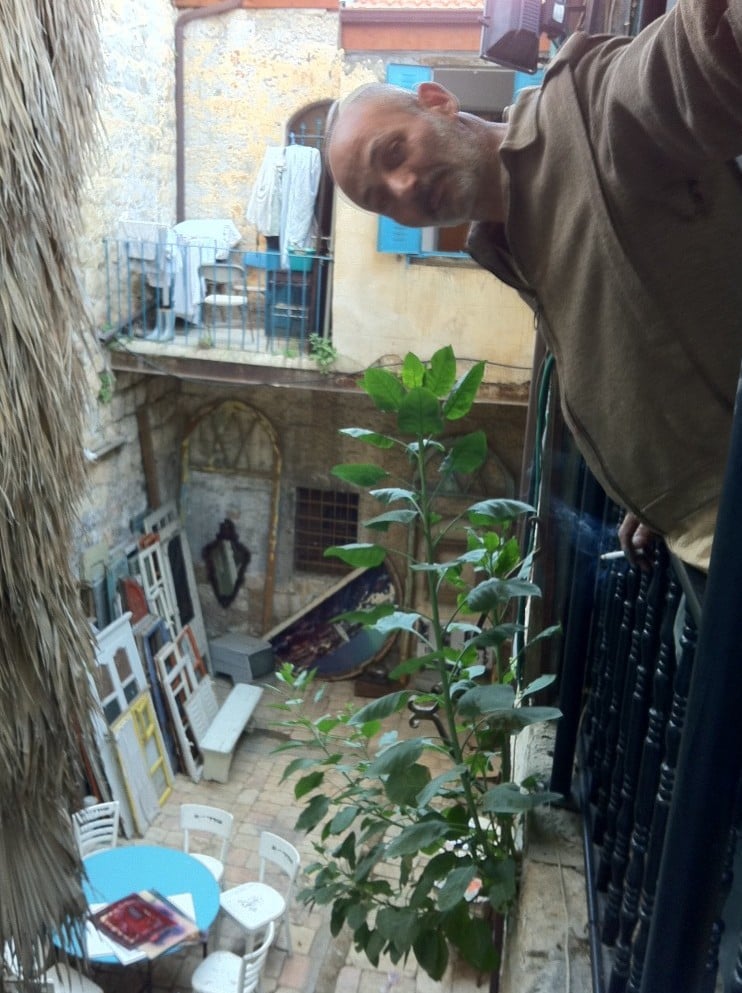 Yoram Amir in the external sitting area of the Tower and Story Museum and Robbers of Jerusalem Gallery. (Photo credit: Greg Tepper)