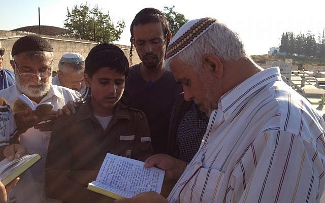 Members of the Zandani family pray at Aharon's grave in Rehovot (photo credit: Elhanan Miller/Times of Israel)